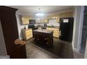 Cozy kitchen with ample cabinetry, a functional island, black appliances, and neutral tile flooring at 750 Gates Ln, Alpharetta, GA 30022