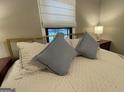 Comfortable bedroom with plush pillows, a large window, and a bedside table at 727 Channing Dr, Atlanta, GA 30318