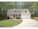 Inviting home with green lawn, attached two-car garage, and dormer windows at 6435 Philips Creek Dr, Cumming, GA 30041