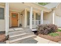 Charming front porch with wooden door, white columns, and well-maintained landscaping adding curb appeal at 6435 Philips Creek Dr, Cumming, GA 30041
