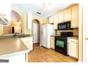 Bright kitchen features ample cabinetry, tile floor, and modern appliances at 6844 Saganaw Dr, Rex, GA 30273