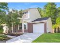 Two-story home with brick accents, a well-maintained lawn, and a driveway leading to an attached garage at 7161 Bowie Dr, Lithonia, GA 30038