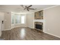 Inviting living room featuring a decorative stone fireplace, ceiling fan, and a large bay window at 7161 Bowie Dr, Lithonia, GA 30038