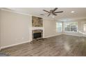 Spacious living room boasts a stone fireplace, ceiling fan, and ample natural light at 7161 Bowie Dr, Lithonia, GA 30038