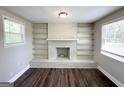 Inviting living area with a white brick fireplace, built-in shelves, dark floors, and natural light from two windows at 2361 Whites Mill Rd, Decatur, GA 30032