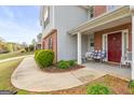 Inviting front porch featuring seating and a red front door, complemented by manicured landscaping at 3156 Oak Ridge Ln, Loganville, GA 30052