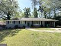 Charming one-story home with a gray painted brick exterior, walkway, and attached carport at 3191 Gay Dr, Decatur, GA 30032