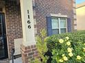A close up of the house number, brick facade, black shutters and landscaped bushes with roses at 1166 Vienna Ct, Hampton, GA 30228