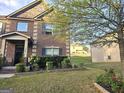 Two story brick home with manicured flower bed and lawn at 1166 Vienna Ct, Hampton, GA 30228