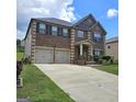 Charming brick home boasts a two-car garage, covered porch, and well-maintained landscaping at 1166 Vienna Ct, Hampton, GA 30228
