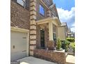 Covered front porch with brick columns and trim, complemented by neatly landscaped flowerbeds at 1166 Vienna Ct, Hampton, GA 30228