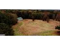 Aerial view of barn surrounded by trees and a grass field on the property at 5300 Salem Rd, Covington, GA 30016