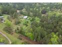 A bird's eye view of a rural property surrounded by lush trees and a long driveway at 24 Shiloh Church Rd, Carrollton, GA 30116