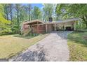 View of house with covered parking, a large driveway, and outdoor space at 9155 Lakeview Sw Dr, Covington, GA 30014