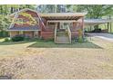 Exterior of home with covered parking and a spacious yard and deck at 9155 Lakeview Sw Dr, Covington, GA 30014