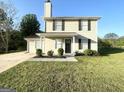 Traditional home featuring neutral siding, black shutters, and tidy landscaping at 825 Rapid Ct, Mcdonough, GA 30252