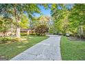 Long driveway leading to home surrounded by lush greenery and mature trees at 215 North Mourning Dove N Dr, Fayetteville, GA 30215