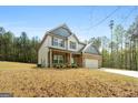 Attractive two-story house featuring brick and siding accents, a two-car garage, and a landscaped yard at 1011 Austin Rd, Ellenwood, GA 30294
