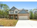 Well-maintained two-story home with brick accents, a two-car garage, and a manicured lawn in a quiet setting at 1011 Austin Rd, Ellenwood, GA 30294