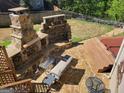 Landscaped backyard features a stone fireplace, hot tub, and patio for outdoor entertaining at 1007 Oglethorpe Ct, Woodstock, GA 30188