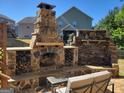 Backyard view featuring outdoor fireplace and built in firewood storage at 1007 Oglethorpe Ct, Woodstock, GA 30188