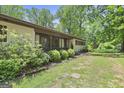 Charming single-story home with a covered porch and lush landscaping, creating a welcoming entrance at 482 E Lake Rd, Mcdonough, GA 30252