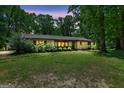 Charming single-story home with a well-maintained lawn and mature trees during evening, offering curb appeal at 482 E Lake Rd, Mcdonough, GA 30252