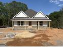 Charming exterior featuring white siding, brick accents, a covered porch, and a new roof at 95 Rome St, Temple, GA 30179