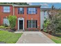 Charming brick townhome featuring black shutters, large windows, and a well-maintained front yard at 1372 Hollenbeck Ln, Riverdale, GA 30296
