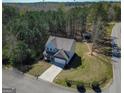 Aerial shot of a two-story home with a long driveway, surrounded by lush trees and greenery at 101 Greenfield Ln, Grantville, GA 30220