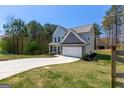 A lush, green lawn surrounds this two-story home with a spacious driveway on a sunny day at 101 Greenfield Ln, Grantville, GA 30220