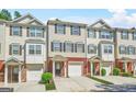 Exterior view of charming townhomes with brick accents and attached garages on a sunny day at 6887 Slate Stone Se Way # 3, Mableton, GA 30126