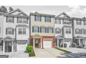 Exterior view of charming townhomes with brick accents and attached garages on a sunny day at 6887 Slate Stone Se Way # 3, Mableton, GA 30126