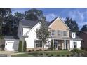 Charming two-story home with a brick and white exterior, landscaped yard, and attached garage at 5875 Windjammer Pt, Cumming, GA 30041