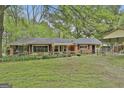 Brick home with well-maintained lawn, complemented by mature trees and a covered parking structure at 2008 Highway 92 S, Fayetteville, GA 30215