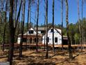 New home under construction surrounded by tall pine trees and a bright blue sky at 0 Pinegate Way, Sharpsburg, GA 30277