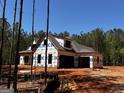 New home construction with visible framing and protective wrap in a wooded setting at 0 Pinegate Way, Sharpsburg, GA 30277