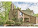 Charming brick home with mature trees and landscaping, featuring an attached garage and arched window at 675 Granby Hill Pl, Alpharetta, GA 30022