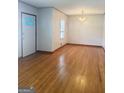 Bright living room with gleaming hardwood floors and natural light from a large window at 6718 Delta Dr, Riverdale, GA 30274