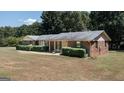 Brick home featuring green shutters and an attached front porch area with nice landscaping at 2215 Mount Carmel Rd, Hampton, GA 30228