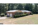 A brick home with an attached two-car garage, manicured hedges, and green shutters at 2215 Mount Carmel Rd, Hampton, GA 30228