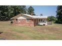 Back view of a brick home with an air conditioning unit and fenced area at 2215 Mount Carmel Rd, Hampton, GA 30228