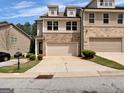 Charming townhome featuring brick accents, a two-car garage, and well-maintained landscaping at 488 Jefferson Chase St, Atlanta, GA 30354