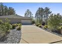 A long driveway leads to a spacious two-car garage, surrounded by neat landscaping at 130 S Meadows Ridge Dr, Grantville, GA 30220