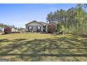 A well-manicured front yard with lush green grass, colorful shrubs, and a charming home at 130 S Meadows Ridge Dr, Grantville, GA 30220