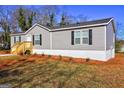 Lovely exterior showcasing gray siding, black shutters, and a new wood porch, surrounded by a tidy yard at 36 Highpoint Ln, Locust Grove, GA 30248