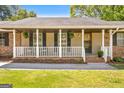 Close-up of a charming front porch with white railings and hanging plants adding to its curb appeal at 25 Hickory Dr, Stockbridge, GA 30281