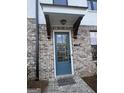 Close-up of front entrance with brick facade, blue door, and 'hello' doormat, showcasing a welcoming entryway at 1117 Larkin Dr, Buford, GA 30518