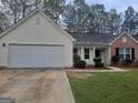 Inviting single-Gathering home with a two-car garage, neat landscaping, and a mix of brick and vinyl siding at 114 Revere Turn, Fairburn, GA 30213