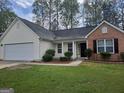 Welcoming single-Gathering residence showcases a two-car garage, lovely landscaping, and a blend of brick and siding at 114 Revere Turn, Fairburn, GA 30213